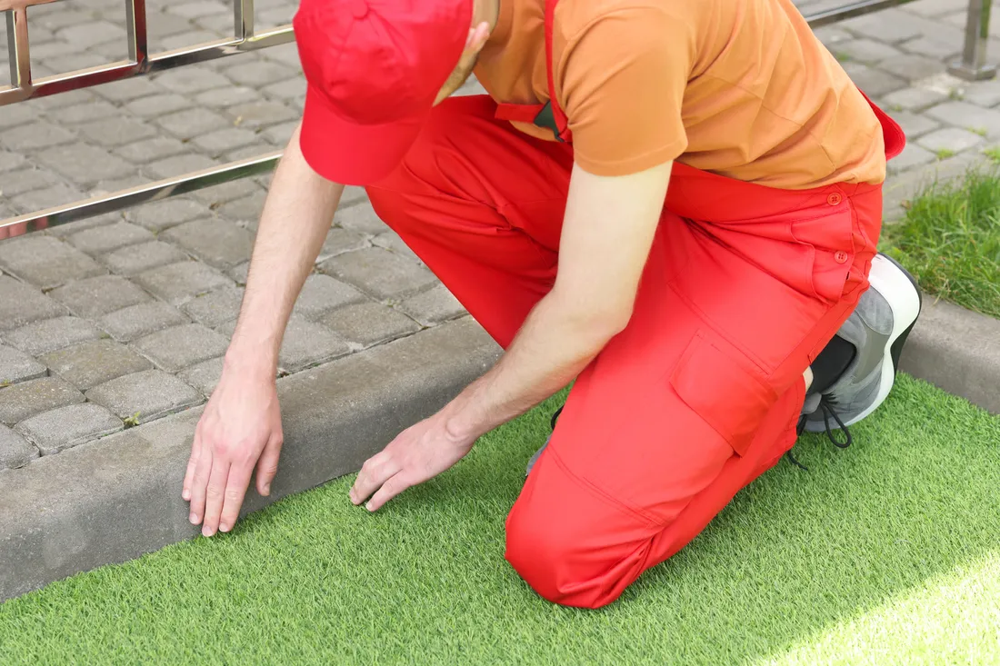 Artificial turf being trimmed to shape during installation